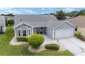 Charming single-story home with a well-manicured lawn, beautiful landscaping, and a two-car garage at 2608 Casso Ct, The Villages, FL 32162