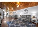 Cozy living room with wood ceiling, comfortable seating, and view into kitchen and dining area at 3299 County Road 521, Wildwood, FL 34785