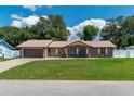 Inviting single-story brick home with a spacious front yard and attached two-car garage at 3881 Se 61St Pl, Ocala, FL 34480