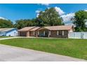Charming brick home with a well-maintained lawn, covered porch, and attached garage at 3881 Se 61St Pl, Ocala, FL 34480