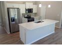 Bright kitchen featuring stainless steel appliances and an island with a quartz countertop at 4121 Se 138Th Pl, Summerfield, FL 34491