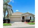 Beautiful single-story home showcases a wide driveway and lush landscaping at 5009 Neptune Cir, Oxford, FL 34484