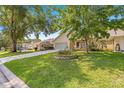 Landscaped lawn of a single-story home that has a long driveway and beautiful shade trees at 8710 Sw 91St St # E, Ocala, FL 34481