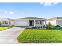 Charming single-story home boasts a well-manicured lawn, two-car garage, and welcoming front entrance at 8816 Sw 69Th Place Rd, Ocala, FL 34481