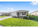 A single-story house showcases well-maintained landscaping, a two-car garage, and a welcoming facade at 8816 Sw 69Th Place Rd, Ocala, FL 34481