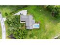 Aerial view of a private home featuring a screened pool, driveway, and lush green landscaping at 8940 Sw 8Th St, Ocala, FL 34481