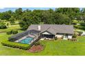 A beautiful shot of the back of the home highlighting a screened-in pool and lush backyard landscaping at 8940 Sw 8Th St, Ocala, FL 34481