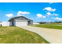 Single-story home with a two-car garage, green grass, and white fence at 10291 Se 67Th Ter, Belleview, FL 34420