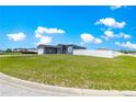 Spacious front lawn with a gray one-story home and white fence at 10291 Se 67Th Ter, Belleview, FL 34420
