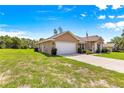 Exterior view showcasing a two-car garage and landscaping, nestled on a well-maintained lawn at 10313 Sw 45Th Ave, Ocala, FL 34476