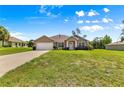 Charming single-story home featuring a well-manicured lawn, attached garage, and classic American flag at 10313 Sw 45Th Ave, Ocala, FL 34476