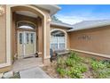 Inviting front porch with a seating area, a beige door with glass inserts, and desert landscaping at 10716 Sw 53Rd Cir, Ocala, FL 34476