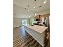 Open kitchen features a large island with granite countertops, modern appliances and a view to living area at 13303 Sw 106Th Pl, Dunnellon, FL 34432