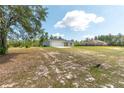 A house in a large grass yard with trees in the background and a neighboring house nearby at 13561 Sw 85Th Pl, Dunnellon, FL 34432