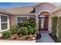 Close-up of the front door surrounded by lush landscaping and a manicured garden at 1377 Sw 161St Pl, Ocala, FL 34473