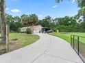 Long, private driveway leads to a three-car garage home featuring solar panels and ample parking space for RV at 16 Count Fleet Dr, Ocala, FL 34482