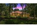 Stately home boasts arched windows, lush landscaping, and a tranquil ambiance under a vibrant, colorful sky at 1675 Se 73Rd Pl, Ocala, FL 34480
