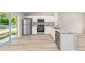 Modern kitchen featuring stainless steel appliances, granite countertops, ample cabinet space, and hardwood flooring at 21301 Sw Rainbow Lakes Blvd, Dunnellon, FL 34431