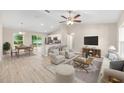 Open-concept living room and kitchen area with natural light, stylish furniture, and vaulted ceilings at 21301 Sw Rainbow Lakes Blvd, Dunnellon, FL 34431
