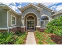 Home featuring a stylish double door entry, stone accents, and professional landscaping at 2417 Se 23Rd St, Ocala, FL 34471