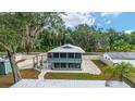 Charming two-story home features a screened-in porch and fenced yard with outdoor seating at 24628 Fox Rd, Astor, FL 32102