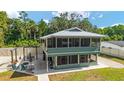 Exterior view of a two-story home with a screened-in porch and outdoor seating area at 24628 Fox Rd, Astor, FL 32102