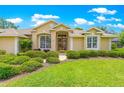 Inviting single-story home with large windows, lush landscaping, and a charming entrance at 28 Golf View Dr, Ocala, FL 34472