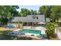 Aerial view of a private backyard featuring a swimming pool, patio area, and mature trees for shade at 2820 Se 14Th St, Ocala, FL 34471