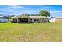 Back exterior of the home shows a large yard and a screened in porch at 2981 Ne 39Th Pl, Ocala, FL 34479