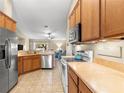 Functional kitchen with wooden cabinets, stainless steel appliances, and an open view to the living area at 3102 Ne 26Th St, Ocala, FL 34470