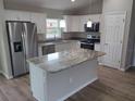Modern kitchen with stainless steel appliances, a center island, and granite countertops at 4105 Se 138Th Pl, Summerfield, FL 34491