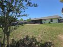 Spacious backyard features a covered patio, a lush lawn, and a privacy fence, perfect for outdoor enjoyment at 5130 Se 106 Lane, Belleview, FL 34420