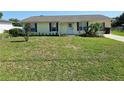 Inviting single-Gathering home with a well-kept lawn and a charming front entrance, complete with flowerbed and dark shutters at 5130 Se 106 Lane, Belleview, FL 34420