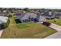 Aerial shot of a single-story house with a well-kept lawn and driveway, complete with a parked red truck at 5920 Sw 88Th Pl, Ocala, FL 34476