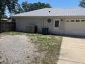 The rear exterior of home shows a garage, fenced yard, and utility area at 6051 Ne 25Th Ave, Ocala, FL 34479