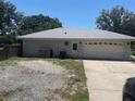 Exterior rear view of a home showing a garage, back entrance, utility box at 6051 Ne 25Th Ave, Ocala, FL 34479