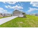 Exterior view of a home with a two-car garage and concrete driveway at 7337 Sw 89Th Ter, Ocala, FL 34481