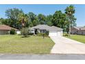 Traditional single-story home with a well-manicured lawn, mature trees, and a two-car garage, offering great curb appeal at 8053 Sw 62Nd Ave, Ocala, FL 34476