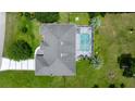 Aerial view of a private home with a screened-in pool and paved driveway, surrounded by greenery at 11140 Sw 53Rd Cir, Ocala, FL 34476