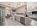 Bright kitchen with white cabinets, tile flooring, and stainless steel appliances open to dining area at 11140 Sw 53Rd Cir, Ocala, FL 34476