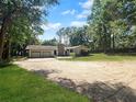 View of the front exterior of home with lush lawn and 3-car garage at 11230 Se 47Th Ave, Belleview, FL 34420