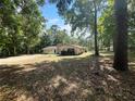 Secluded home exterior with mature trees and a large front yard at 11230 Se 47Th Ave, Belleview, FL 34420