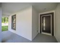 Exterior showcasing the front door and its modern design with dark trim and sidelight window at 13314 Se 41St Ct, Belleview, FL 34420