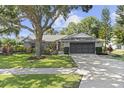 Charming single story home with lush landscaping, well-maintained lawn and a 2-car garage at 15917 Hidden Lake Cir, Clermont, FL 34711