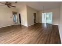 Open-concept living room with wood floors and sliding glass doors to a sunroom at 17522 Se 96Th Ct, Summerfield, FL 34491