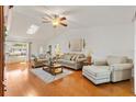Bright living room with vaulted ceiling, skylight, hardwood floors, and comfortable seating at 17576 Se 96Th Ct, Summerfield, FL 34491