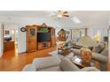 Living room featuring hardwood floors, large entertainment center, and comfortable seating at 17576 Se 96Th Ct, Summerfield, FL 34491