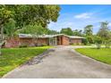 Beautiful brick home with a well-maintained lawn and a long circular driveway at 1852 Ne 39Th Ct, Ocala, FL 34470