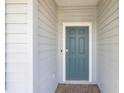 Close-up of the front door, a stylish blue with a modern door handle and smart lock, framed by gray siding at 1875 Nw 44 Ct, Ocala, FL 34482