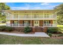 Inviting two-story home features a brick facade, white railings, double balconies, and a green lawn at 20861 Sw 81St Loop, Dunnellon, FL 34431